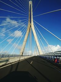 Low angle view of suspension bridge against blue sky