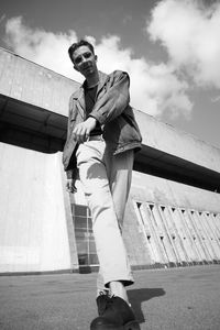 Low angle view of young man standing against sky