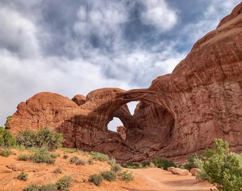 A large red sandstone double arch formation in arches national park