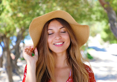 Portrait of smiling young woman wearing hat