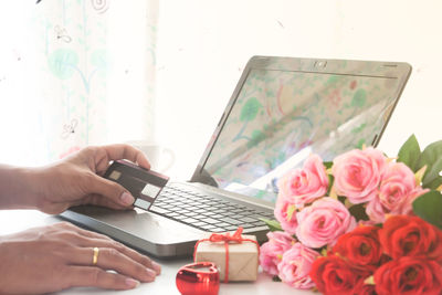 Midsection of woman using mobile phone on table