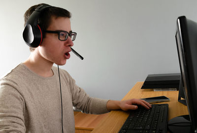 Young man using mobile phone while sitting on table