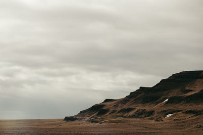 Scenic view of mountains against cloudy sky