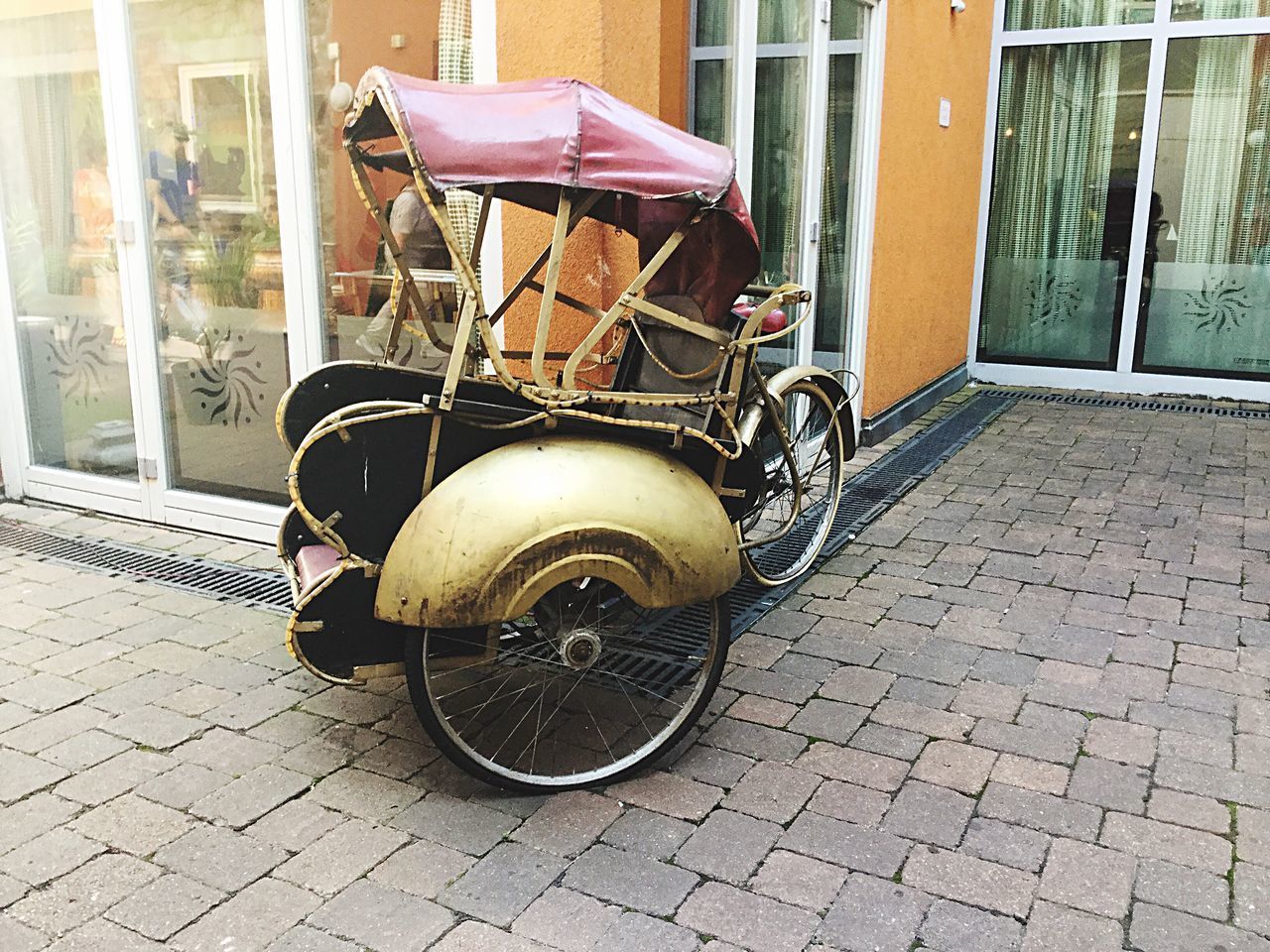 BICYCLE PARKED ON FOOTPATH BY STREET AGAINST BUILDINGS