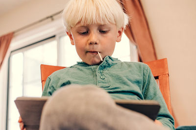 Young boy doing school work on tablet