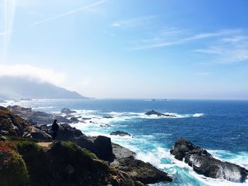 High angle view of rock formations by sea against sky