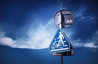 Low angle view of road sign against blue sky