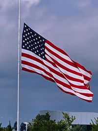 Low angle view of flag flags against sky