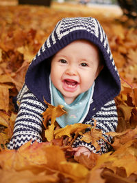 Cute baby girl lying on autumn leaves