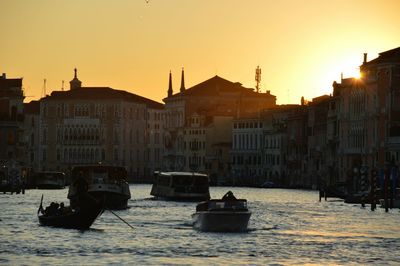 Boats in river at sunset