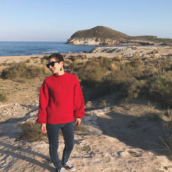 Full length of woman standing on beach against sky