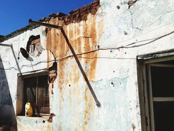 Low angle view of abandoned house against sky