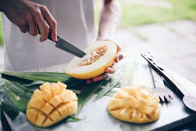 Midsection of man cutting vegetable