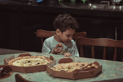 Portrait of boy eating food at home