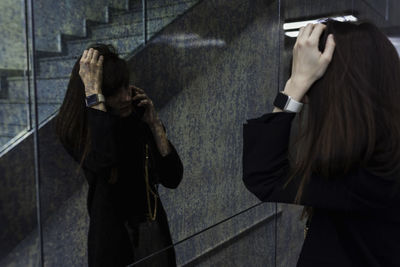 Rear view of woman standing against wall