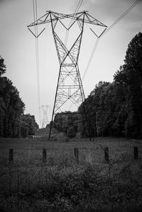 Electricity pylon on field against clear sky