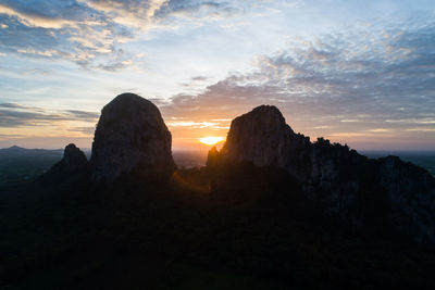 Rock formations on landscape against sky during sunset