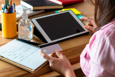 Midsection of woman using smart phone on table