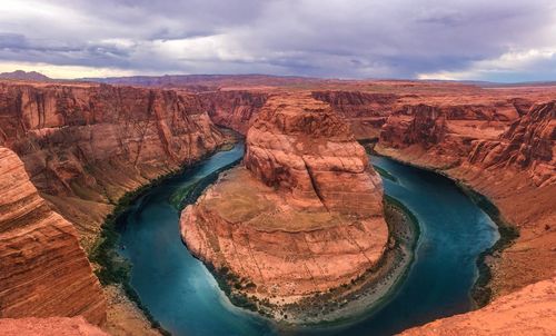 Aerial view of rock formations against cloudy sky