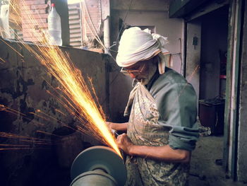 Man welding while standing in workshop