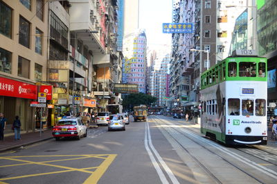 Cars on city street by buildings