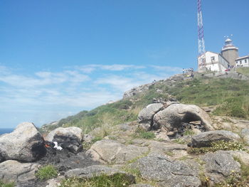 Lighthouse on mountain against blue sky