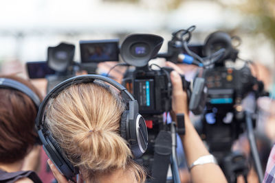 Rear view of women operating cameras during event