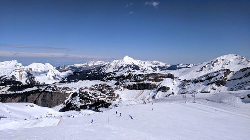 Scenic view of snowcapped mountains against blue sky