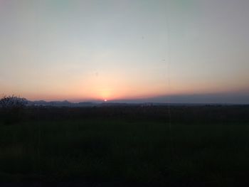 Scenic view of silhouette field against sky during sunset