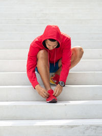 Portrait of young man against red wall