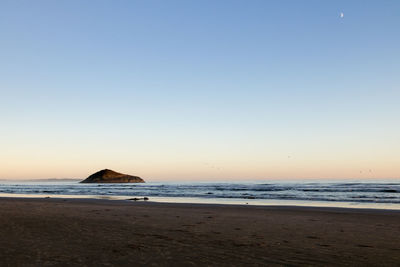Scenic view of sea against clear sky during sunset