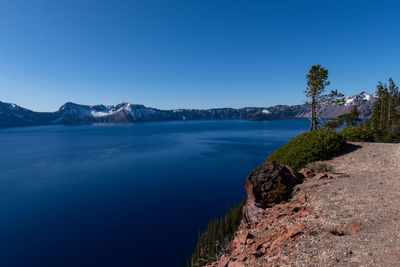 Wide view of rim of crater lake in oregon with clear blue sky