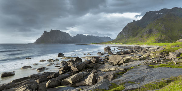 Scenic view of sea and mountains against sky