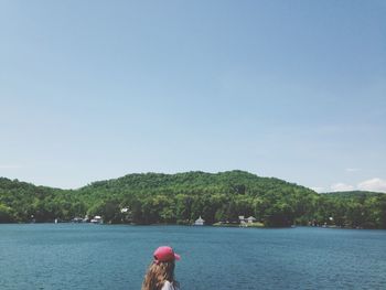 Woman by lake against sky