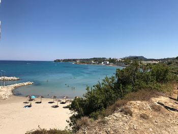 Scenic view of beach against clear blue sky