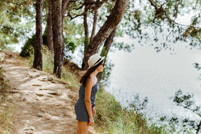 Woman standing by tree trunk