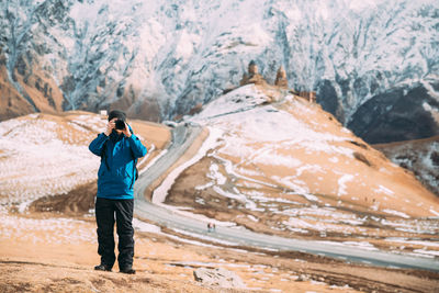 Rear view of man walking on snow