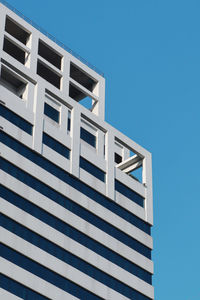 Low angle view of modern building against clear blue sky