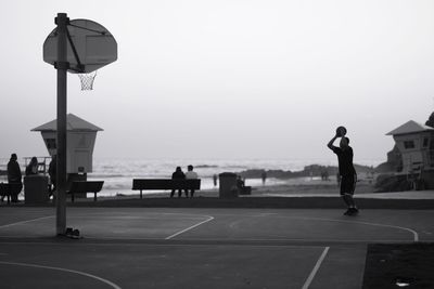 People playing basketball against sky