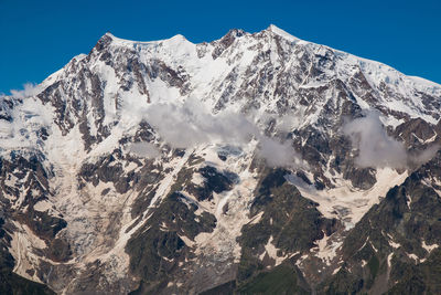 Scenic view of snowcapped mountains against clear sky