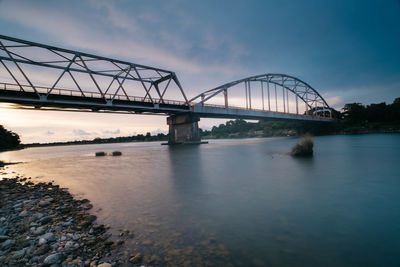 View of bridge over river against cloudy sky