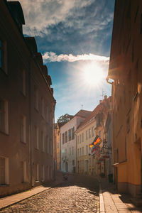 Street amidst buildings against sky during sunset