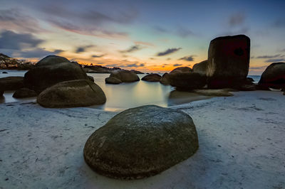 Close-up of stones on beach against sky during sunset