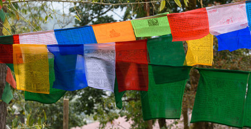 Close-up of multi colored flags hanging outdoors