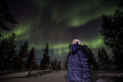 Man on snow covered landscape against sky at night