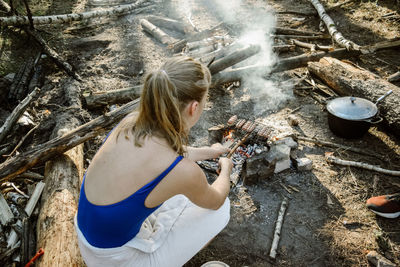 High angle view of woman grilling sausages