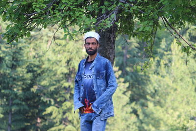 Portrait of young man standing in forest