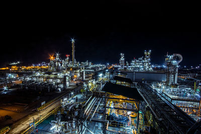 High angle view of illuminated factory against sky at night