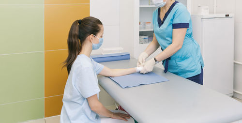 Midsection of doctor examining patient in clinic