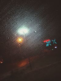 High angle view of wet glass window at night